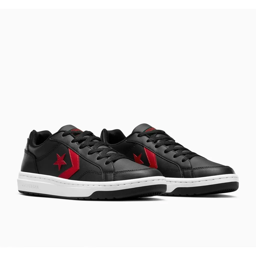 รองเท้า Converse Pro Blaze V2 สีดำตัดกับโลโก้ดาวและเชฟรอนสีแดงโดดเด่น วางคู่กันบนพื้นหลังสีขาว พื้นรองเท้าด้านล่างมีสีขาวและดำ และมีคำว่า "CONVERSE" อยู่ที่ด้านข้างของพื้นรองเท้าด้านซ้ายมือ