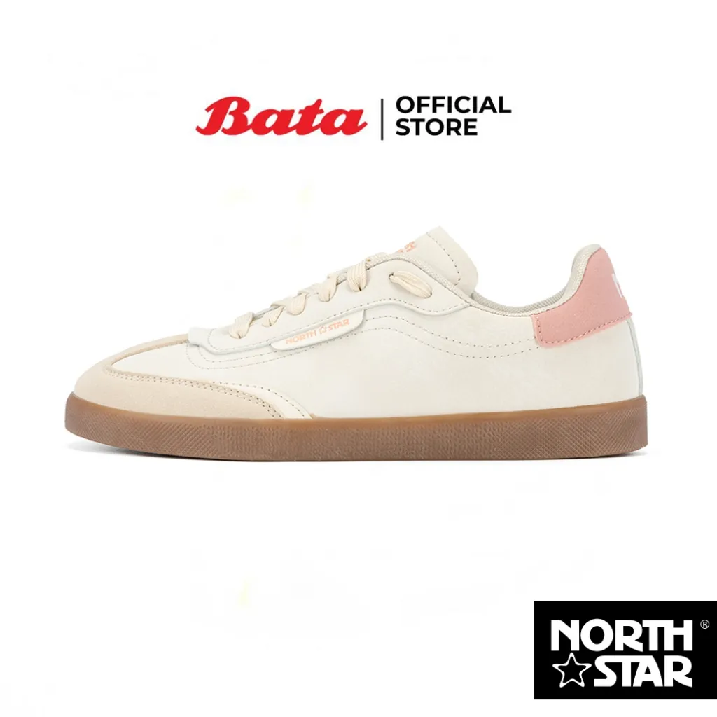 รองเท้าผ้าใบ Bata North Star NEW STRIKER สีเบจและชมพูอ่อน วางอยู่บนพื้นหลังสีขาว ถ่ายจากมุมด้านข้าง แสดงให้เห็นพื้นรองเท้าสีน้ำตาลและรายละเอียดการเย็บ