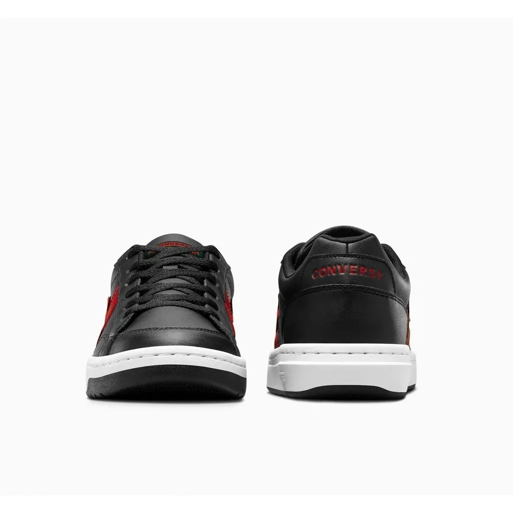 รองเท้า Converse สีดำ-แดง วางคู่กัน โดยหนึ่งข้างหันหน้าออกและอีกข้างหันหลังออก บนพื้นหลังสีขาว ด้านหน้าของรองเท้ามีเชือกสีดำและโลโก้สีแดง ส่วนด้านหลังมีตัวอักษร "CONVERSE" สีแดงสลักอยู่