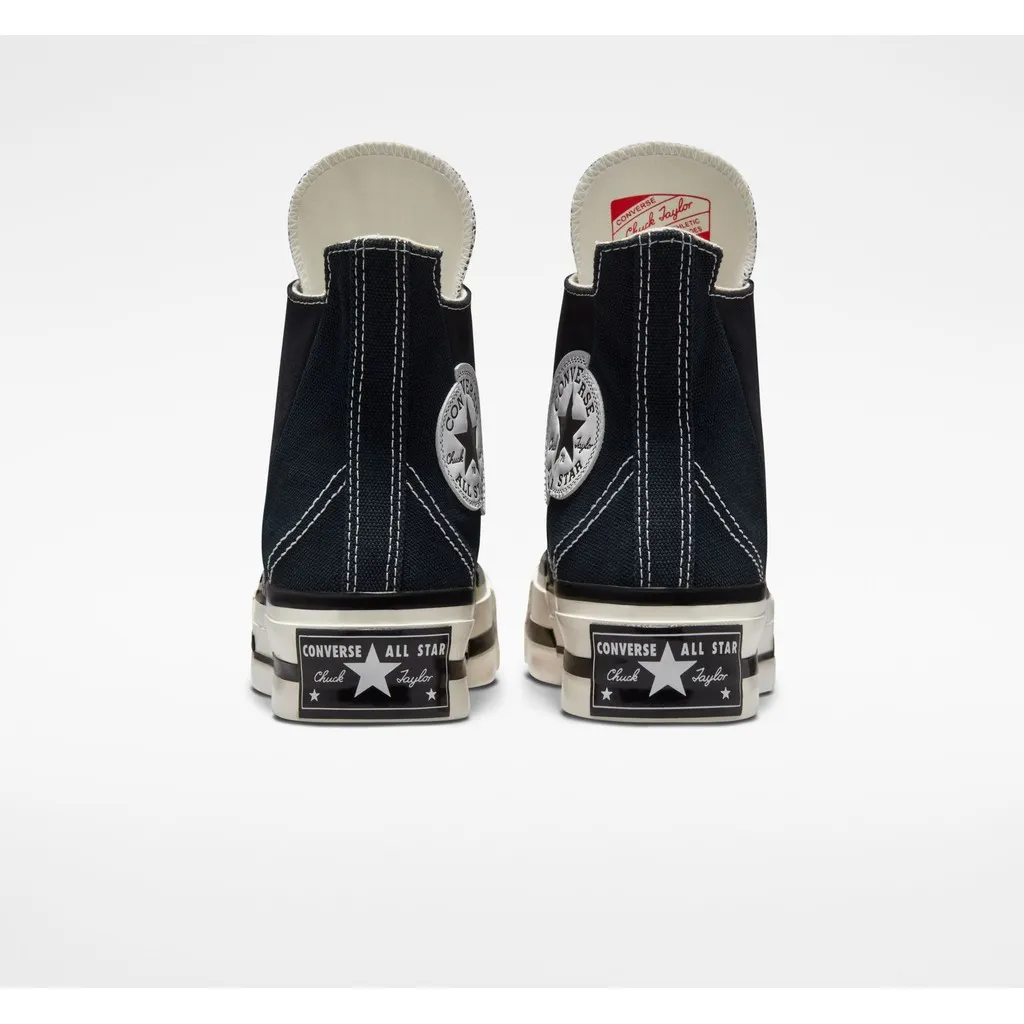 รองเท้าผ้าใบหุ้มข้อสีดำหนึ่งคู่ มองจากด้านหลัง แสดงรายละเอียดโลโก้ Converse All Star บนส้นรองเท้า