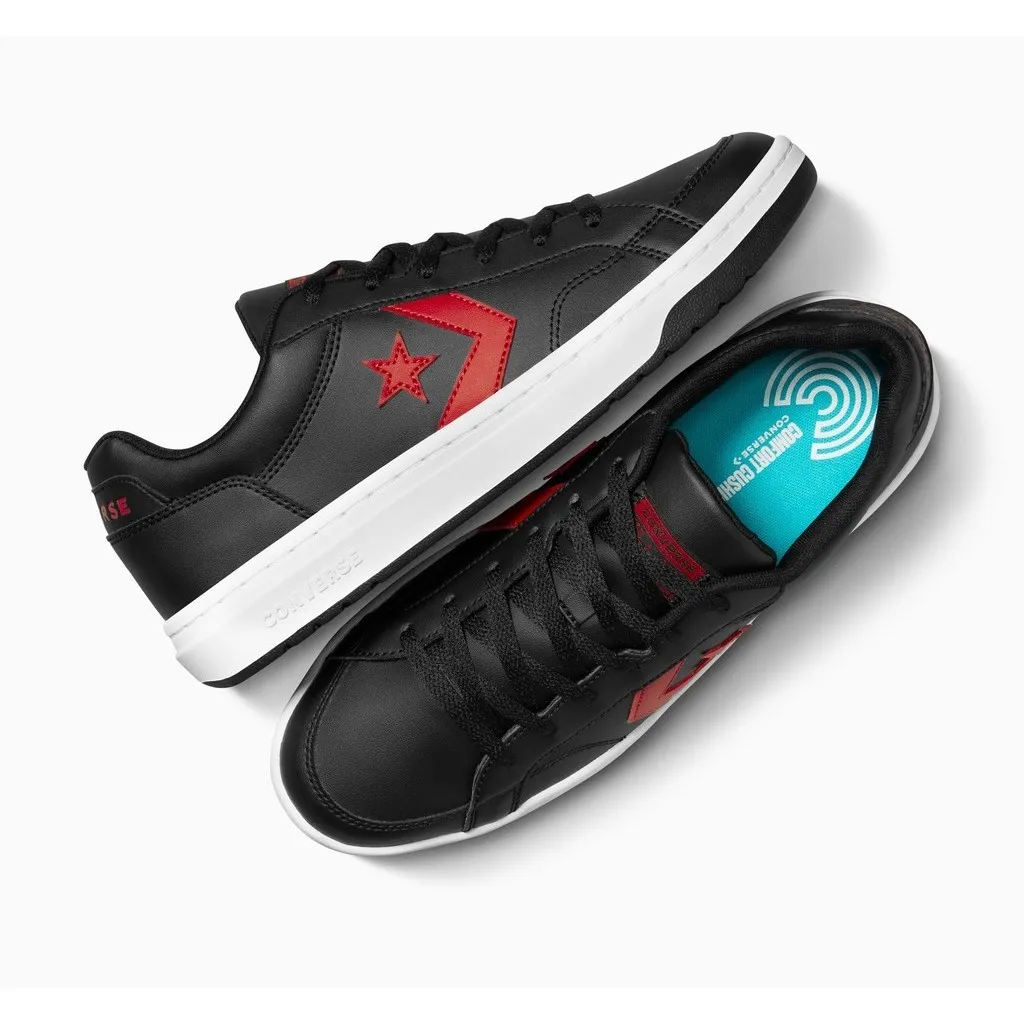 รองเท้า Converse สีดำ-แดง วางคู่กันในมุมมองจากด้านบน โดยรองเท้าด้านบนโชว์ด้านข้างและโลโก้ดาวและเชฟรอนสีแดง ส่วนรองเท้าด้านล่างเผยให้เห็นพื้นรองเท้าด้านในสีฟ้าอ่อนที่มีข้อความ "COMFORT CUSHION" และโลโก้ Converse สีขาว