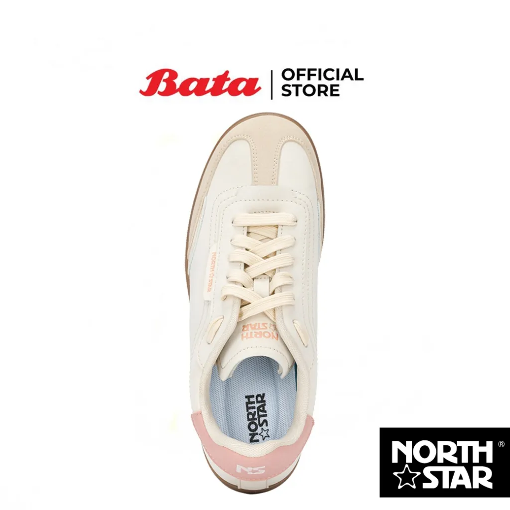 รองเท้าผ้าใบสีเบจและชมพูอ่อนจากแบรนด์ Bata North Star ถ่ายจากมุมบน แสดงให้เห็นเชือกผูกรองเท้าสีอ่อนและโลโก้ North Star บนแผ่นรองด้านใน
