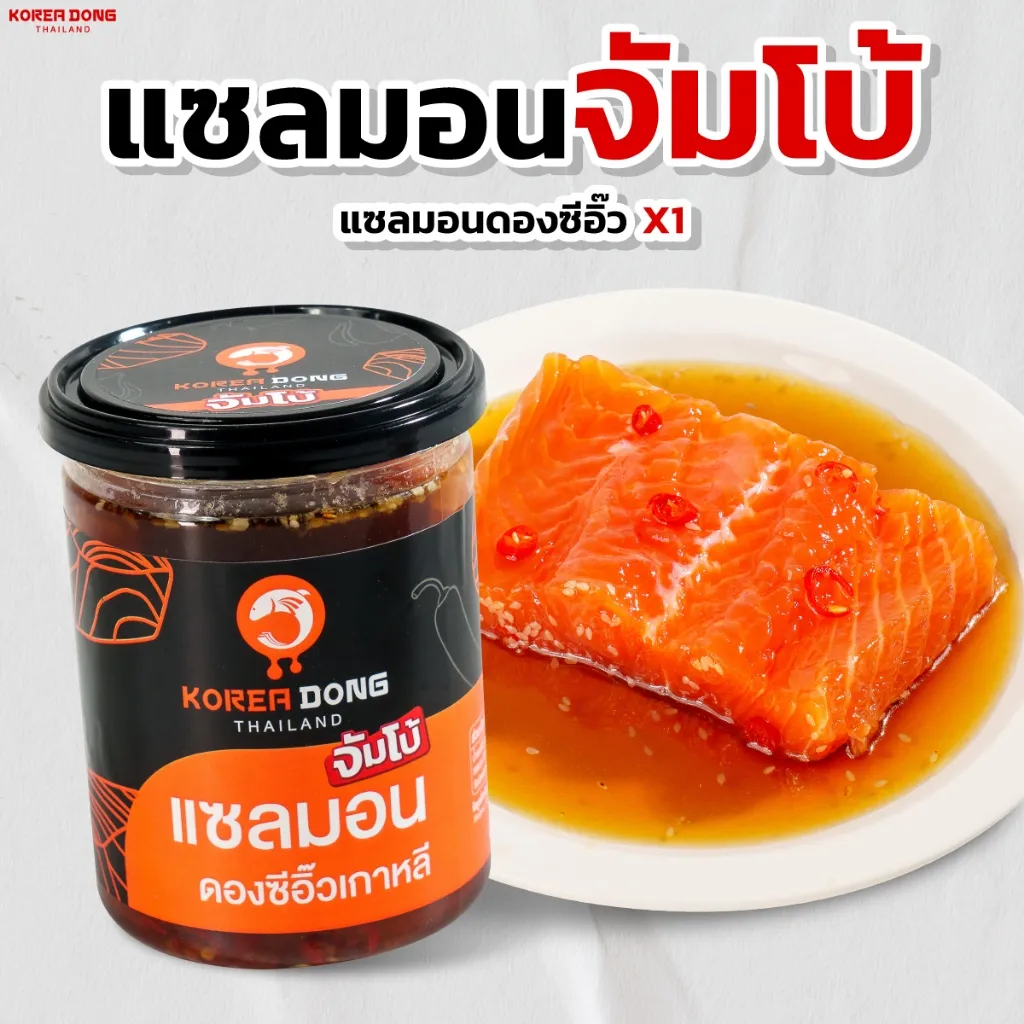 Koreadong แซลมอนดองซีอิ๊ว จัมโบ้ 500 g คู่ขวดจิ้มโป๊ะกับชิ้นปลาสีส้มราดซอสบนจาน พร้อมทาน