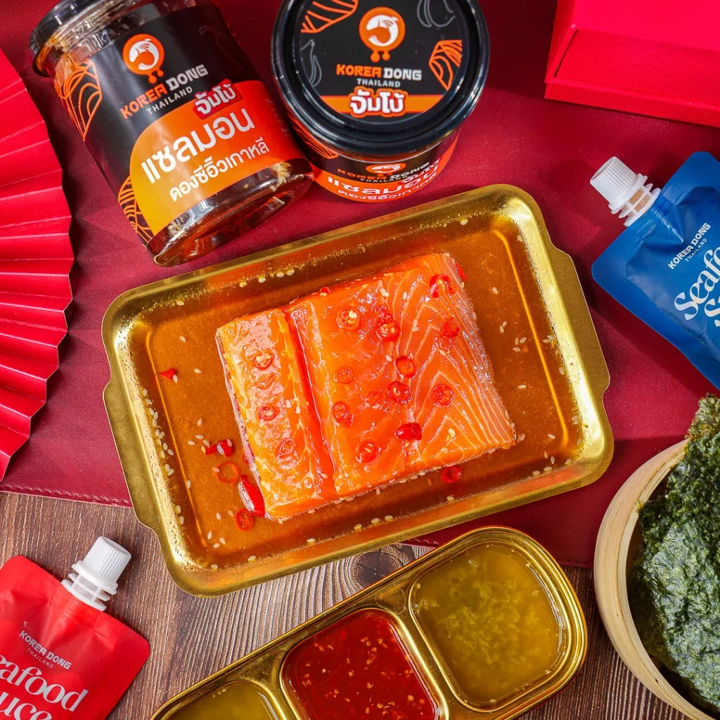 Koreadong แซลมอนดองซีอิ๊ว จัมโบ้ 500 g จัดเซตบนโต๊ะสีแดง มีถาดซอส 3 ช่อง สาหร่าย และชิ้นปลาราดซอส