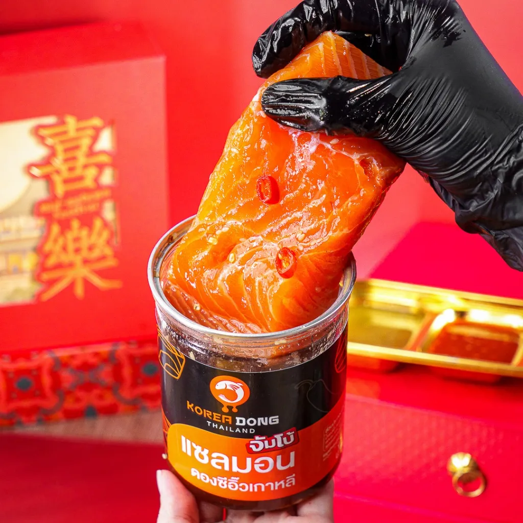 มือสวมถุงมือยกชิ้นปลาออกจากกระปุก Koreadong แซลมอนดองซีอิ๊ว จัมโบ้ 500 g ซอสเงาวาวหยดลงถาด