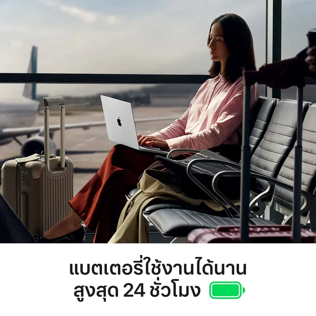 ผู้หญิงนั่งทำงานที่สนามบินข้างกระเป๋าเดินทาง ใช้งาน MacBook Pro M5 14 นิ้ว ได้ต่อเนื่องนาน